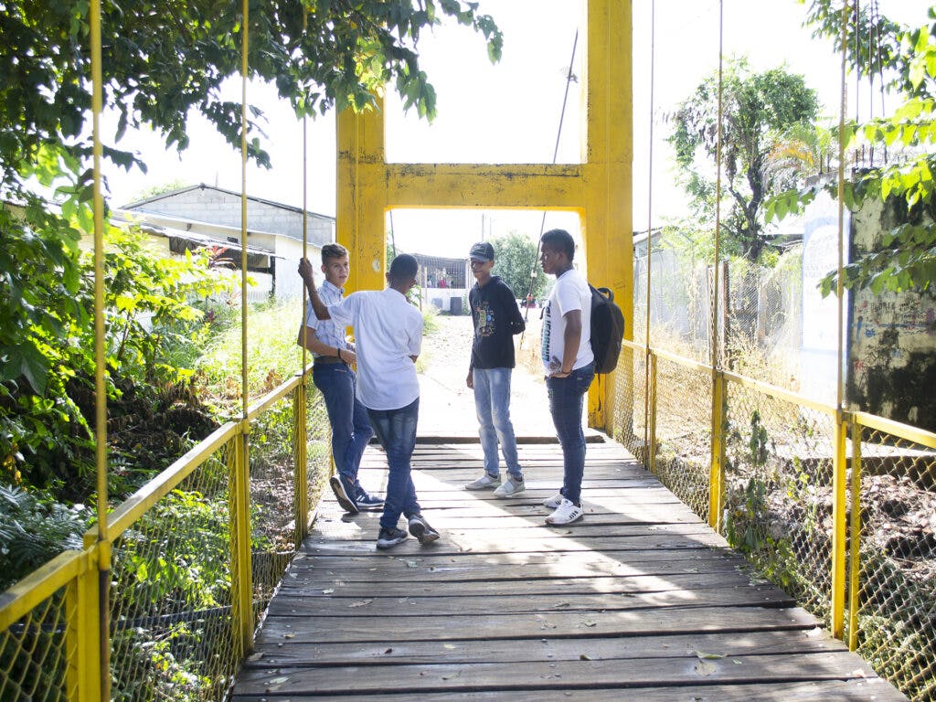 Four boys standing on a bridge