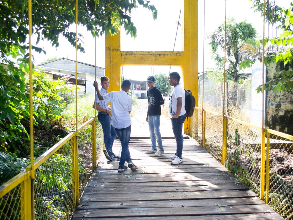 Four boys standing on a bridge