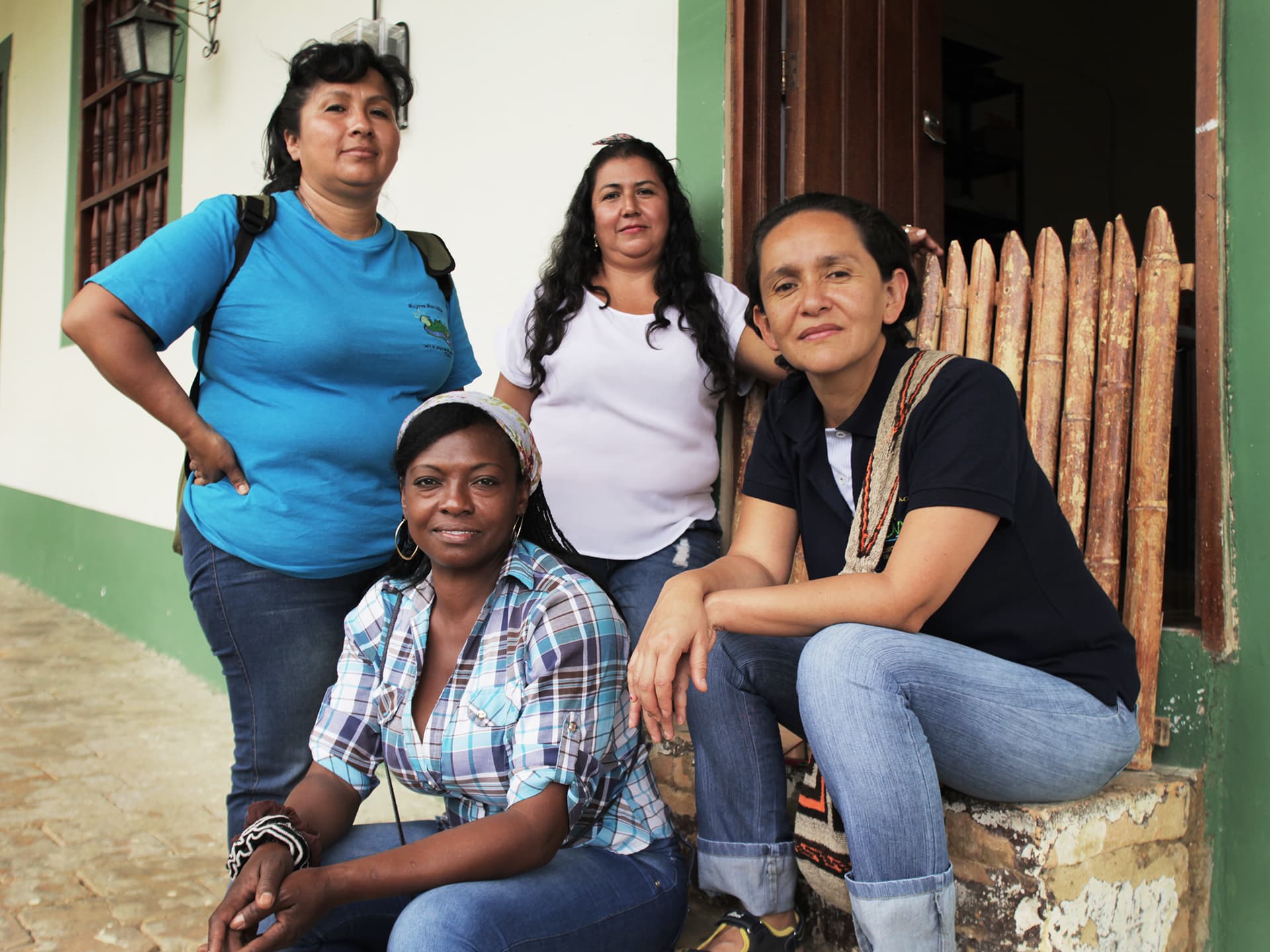 A group of women sitting in a staircase looking into the camera