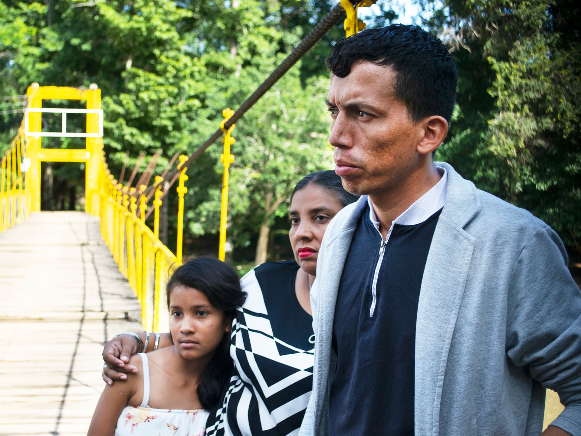 A man, woman and a little girl standing by a bridge