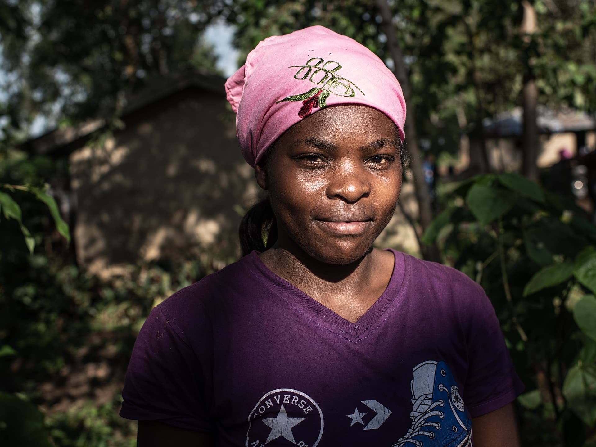 A Kenyan woman standing in the woods-