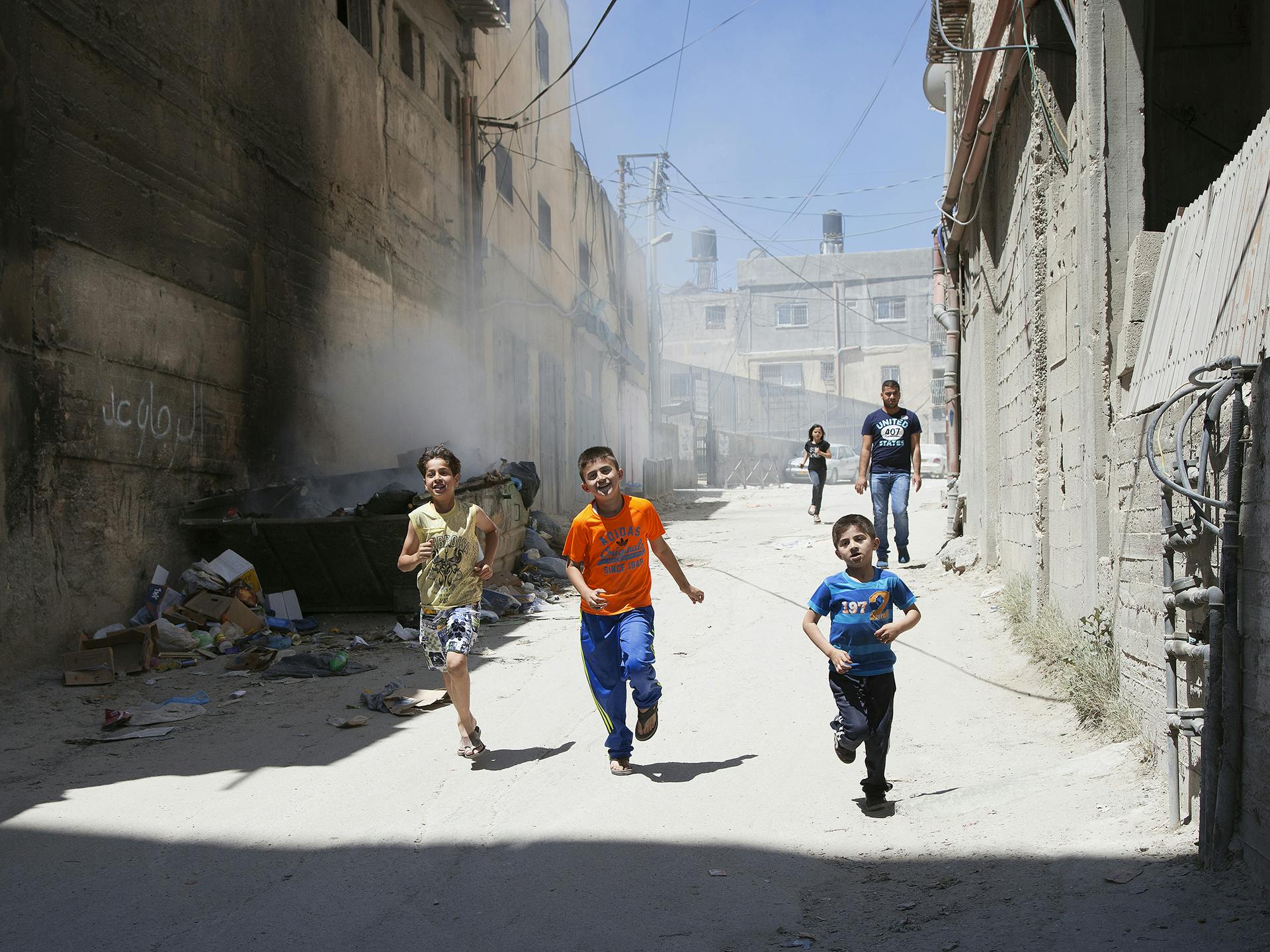 Children running in the streets of a refugee camp