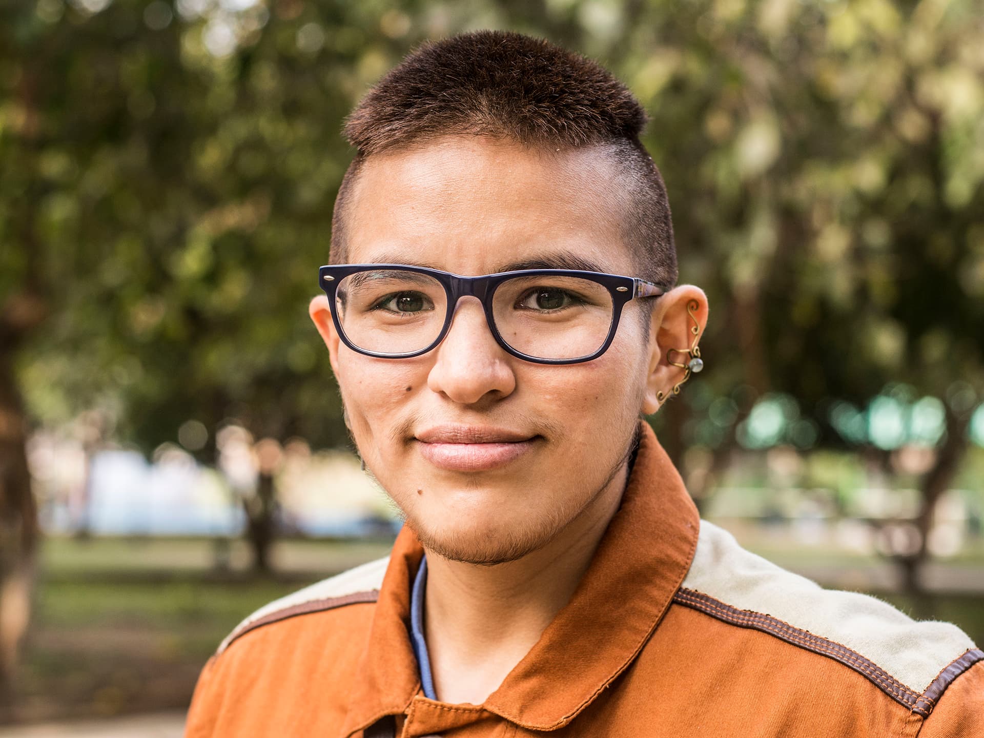 A portrait of a young man with glasses.