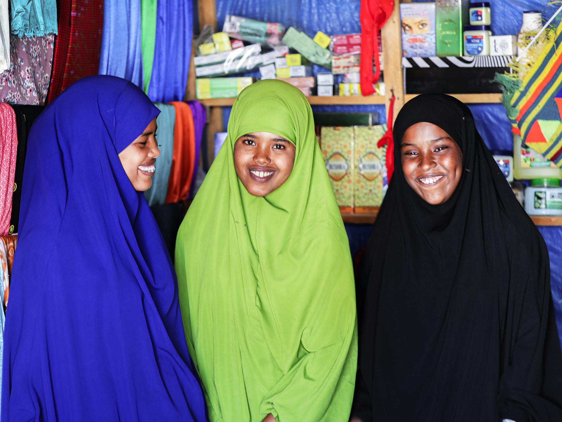 Three somalian women wearing hijab inside a shop.