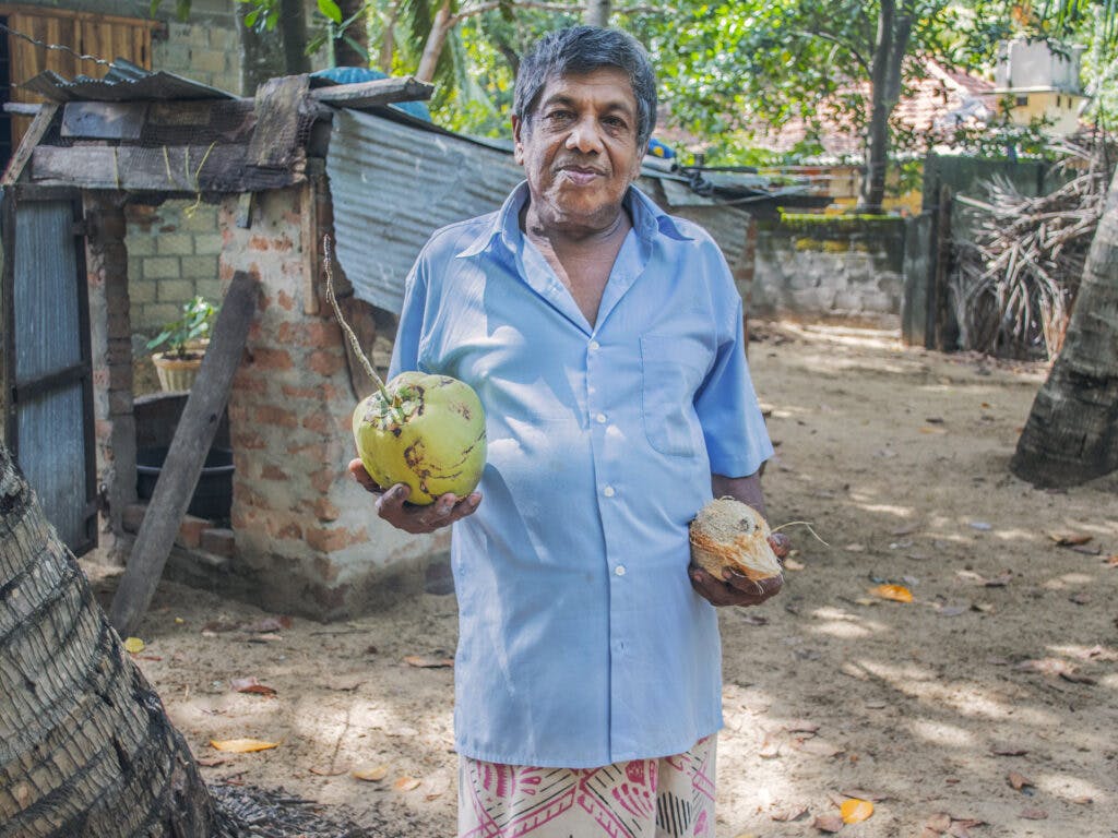 A man carrying two big fruits.