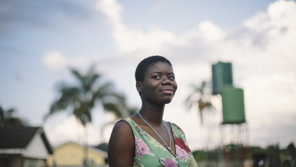 A Zimbabwean woman in sunset, looking into the camera.