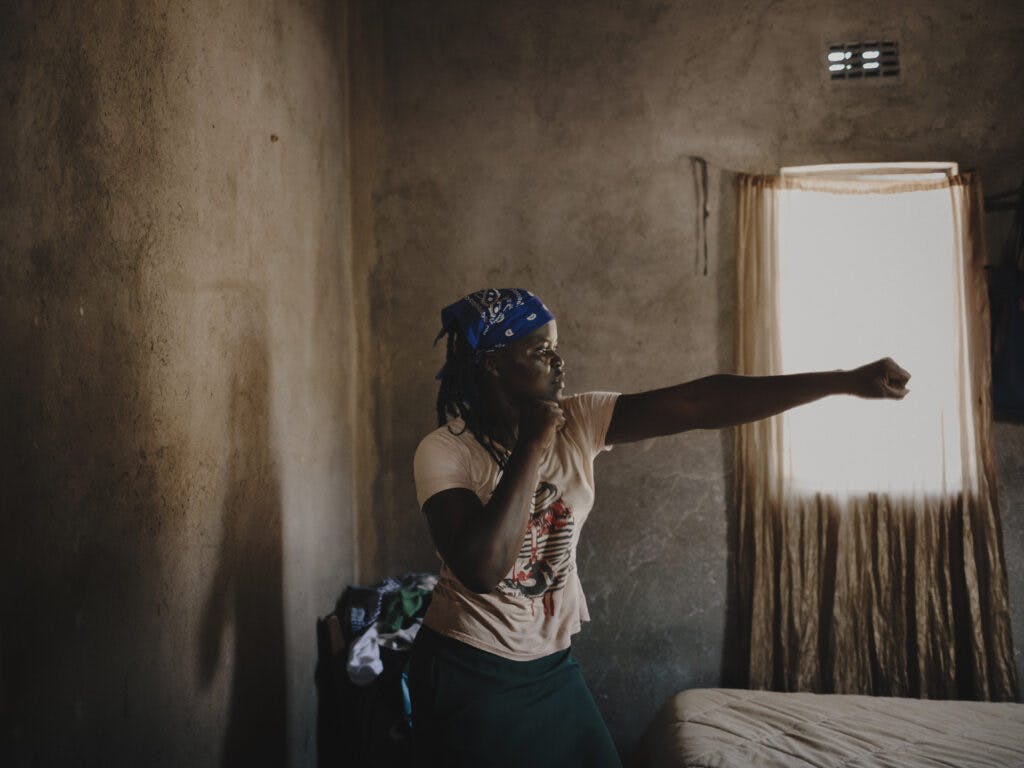 A Zimbabwean woman in a room in a boxing pose.
