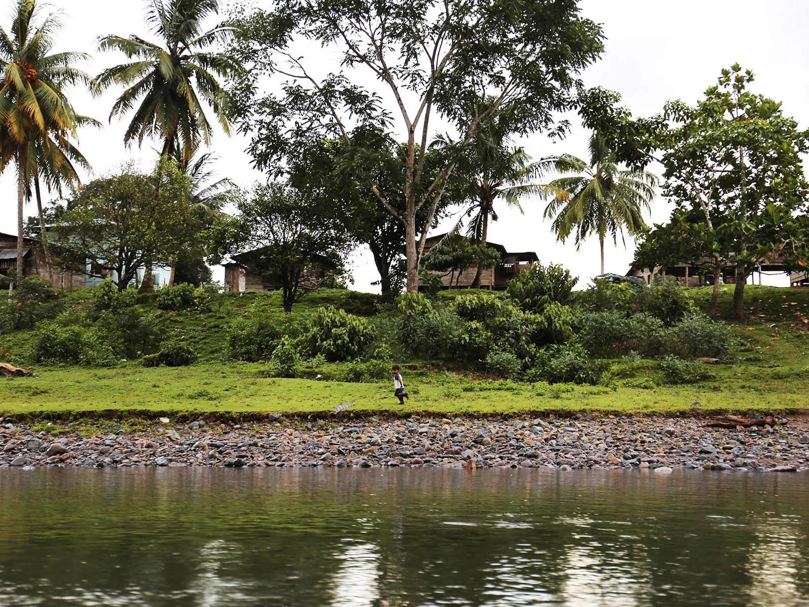 A little child running by the water.