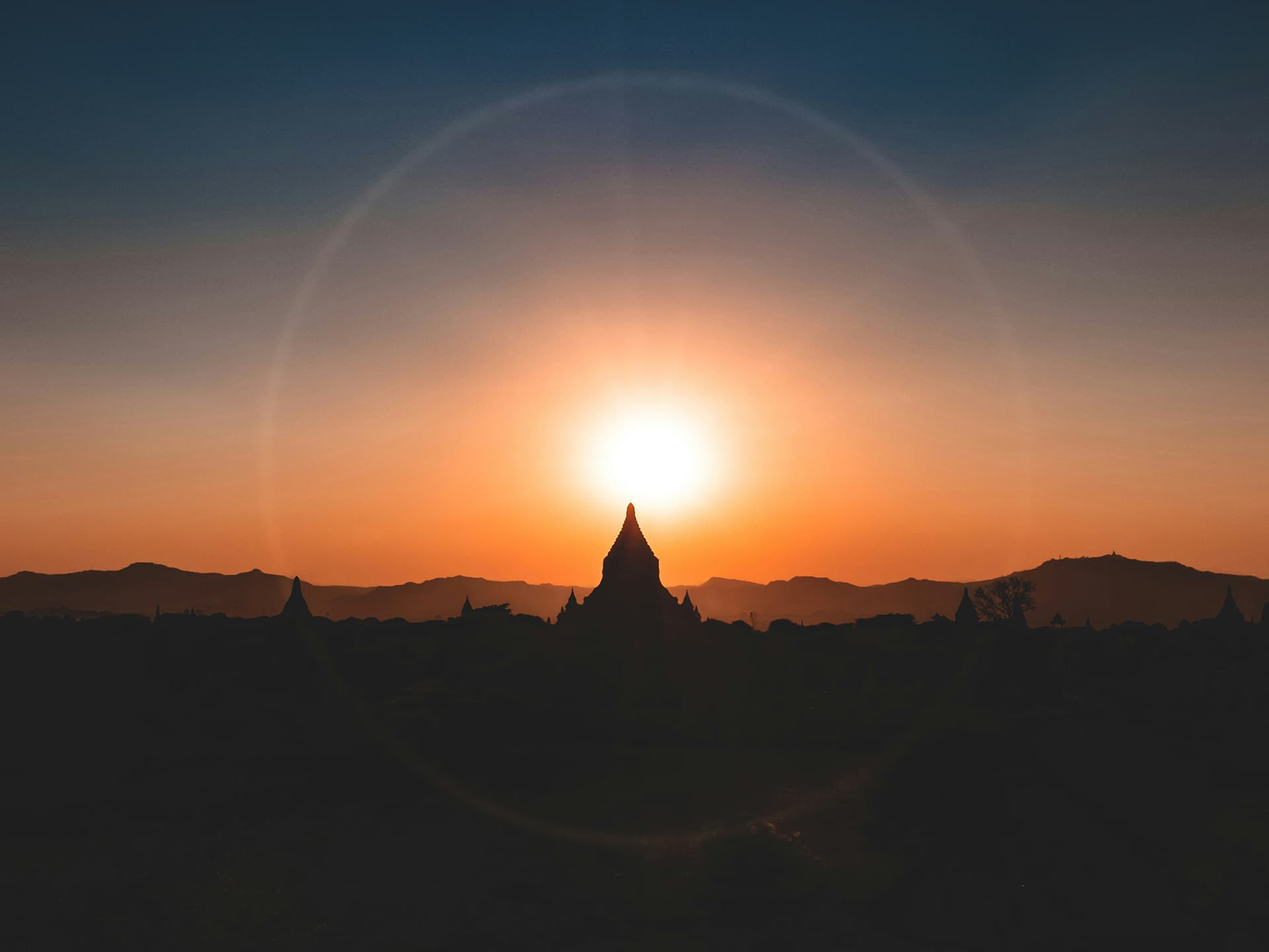 Photo: Jesse Schoff/Unsplash The sun setting over a mountain range in Myanmar.