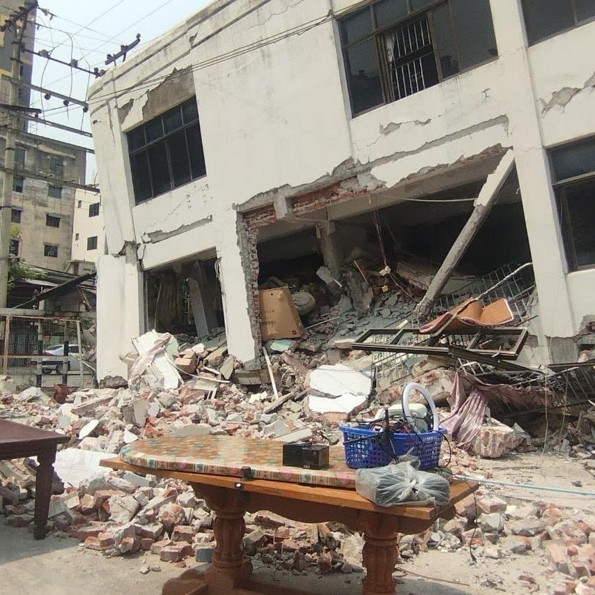 A severely damaged white concrete building with a partially collapsed ground floor following the Myanmar earthquake. Photo courtesy of World Concern Myanmar.