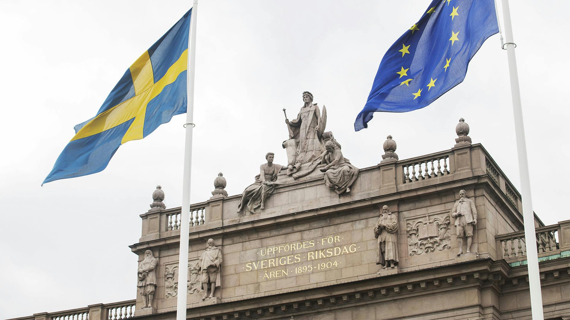 Svenska och europeiska flaggan framför riksdagshuset