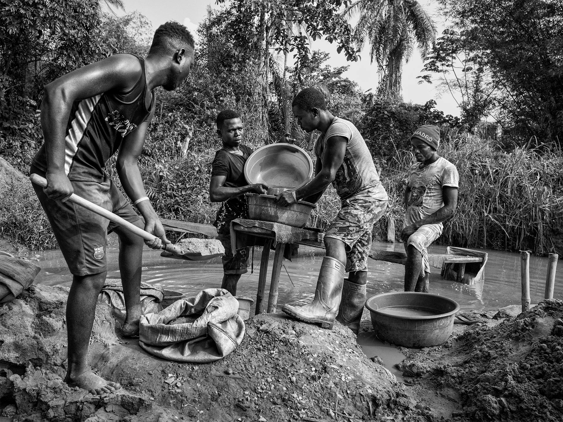 Fyra män vaskar grus i jakt på mineraler