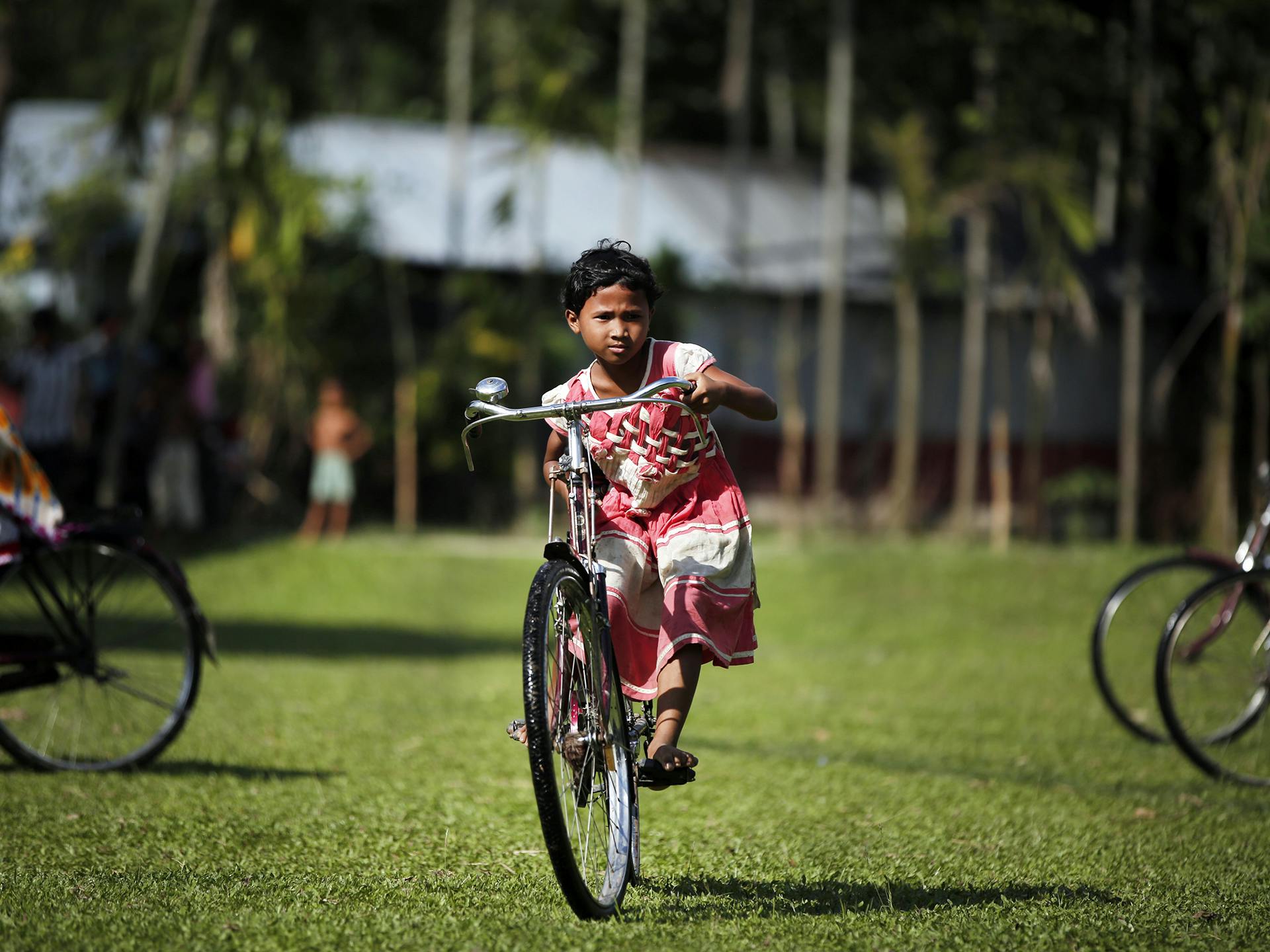 En ung flicka cyklar på en stor cykel.