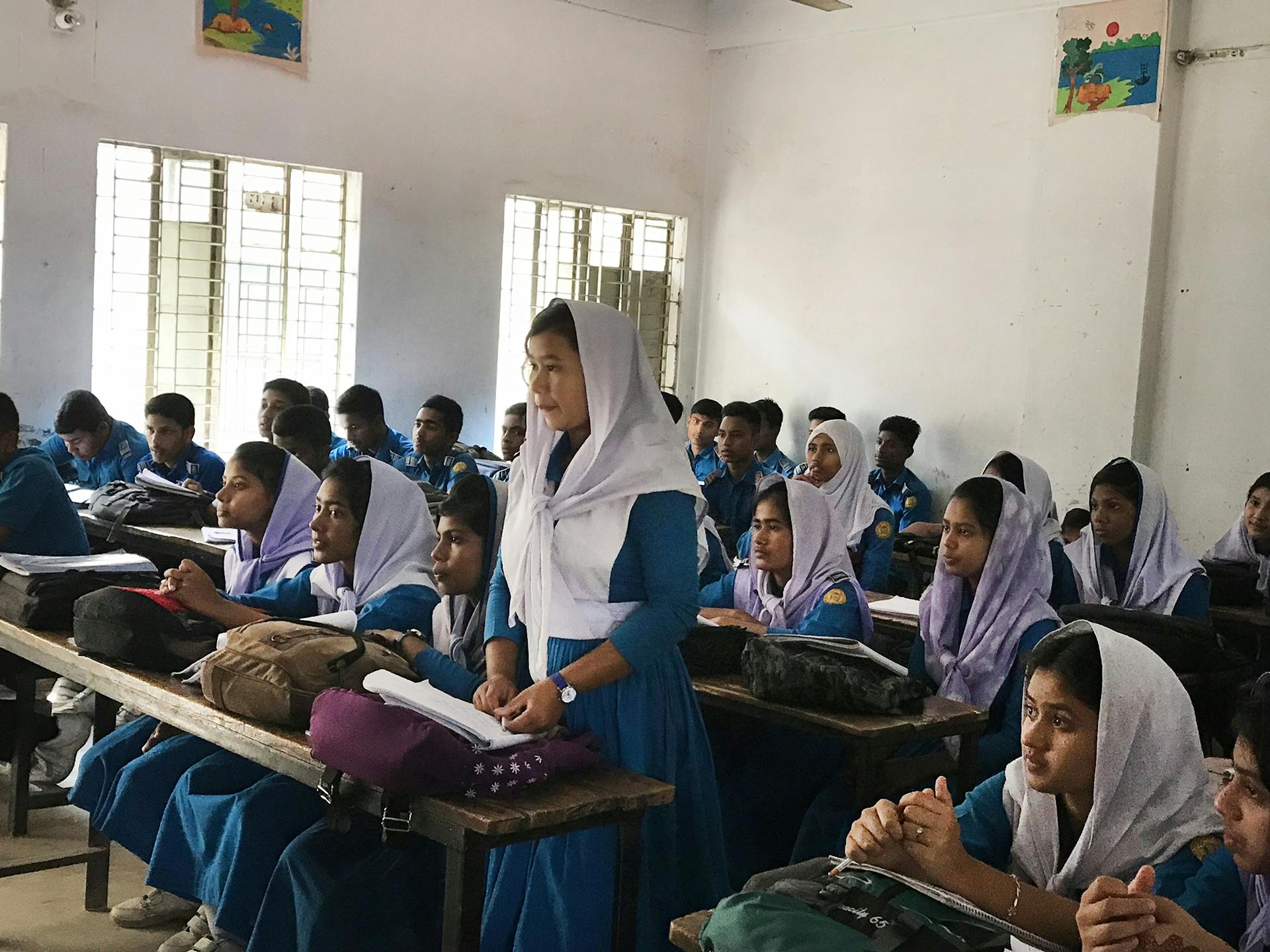 Ett klassrum i Bangladesh med flickor och pojkar i skoluniformer.