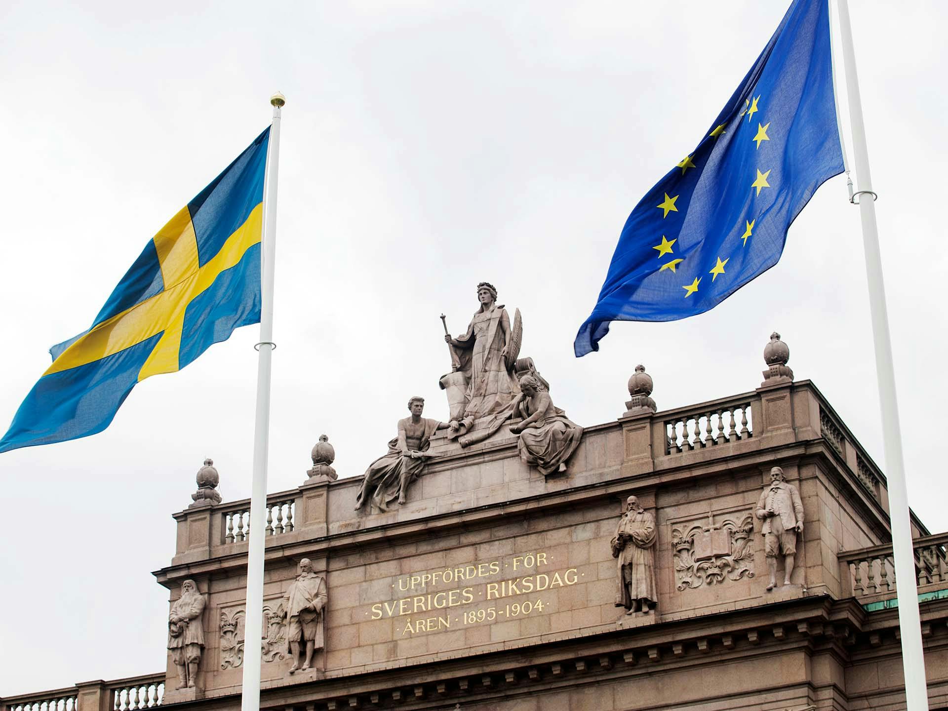 Svenska och europeiska flaggan framför riksdagshuset
