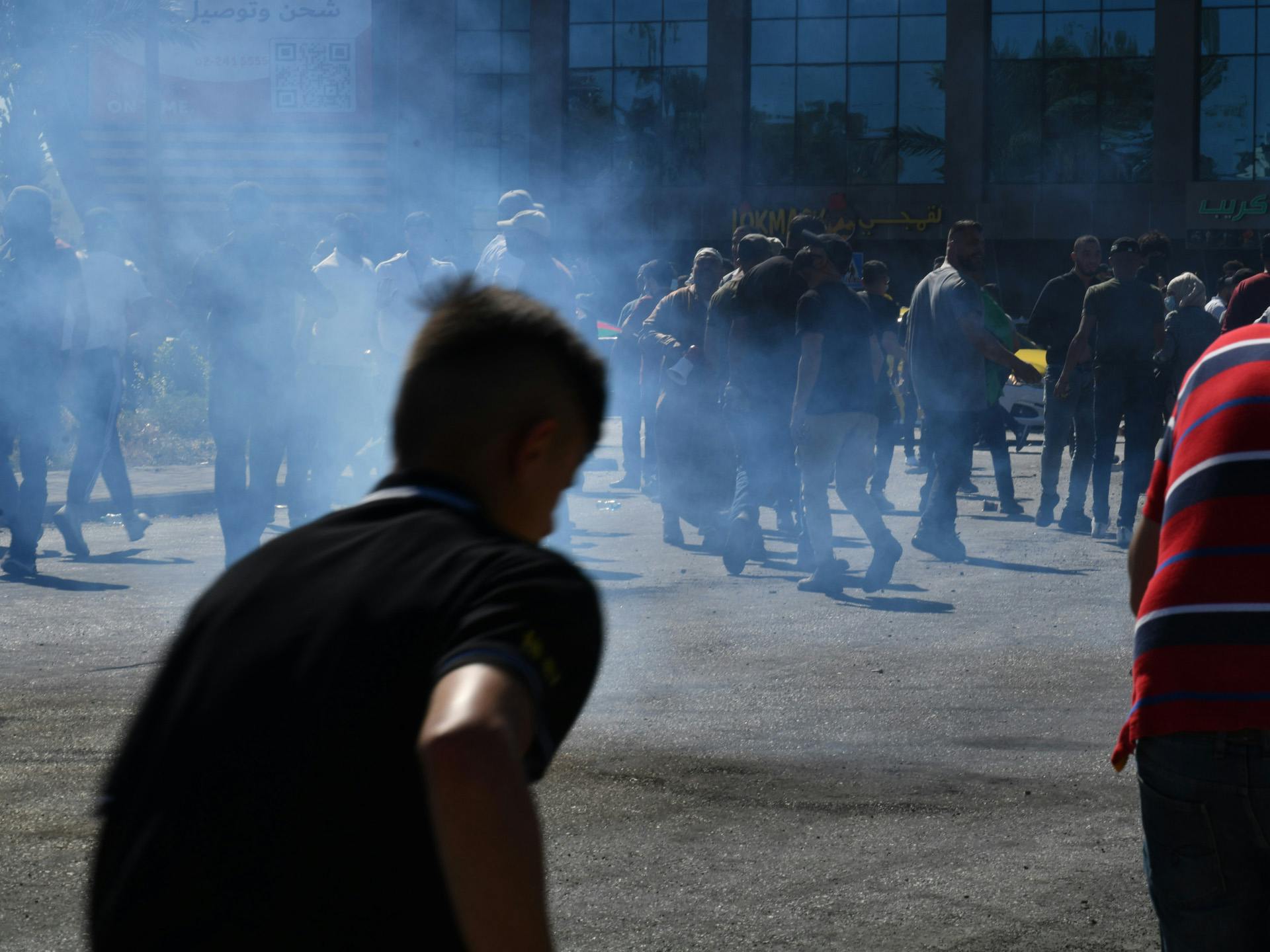 The silhouette of a group of demonstrators in the smoke.