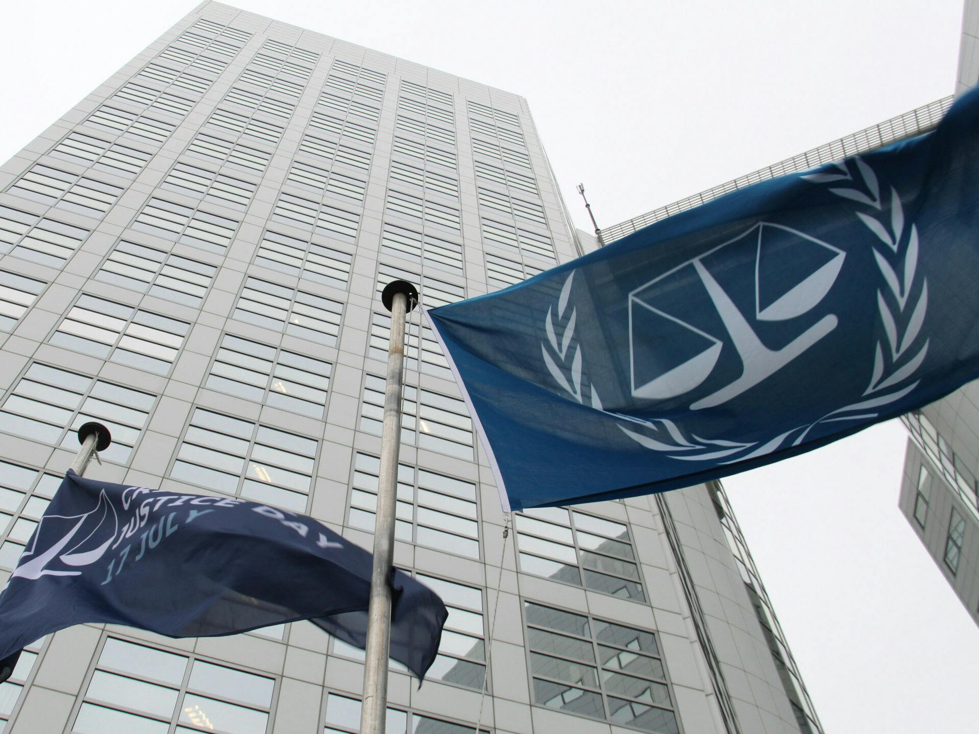 Blue flags of the International Criminal Court in front of the Court's office tower.
