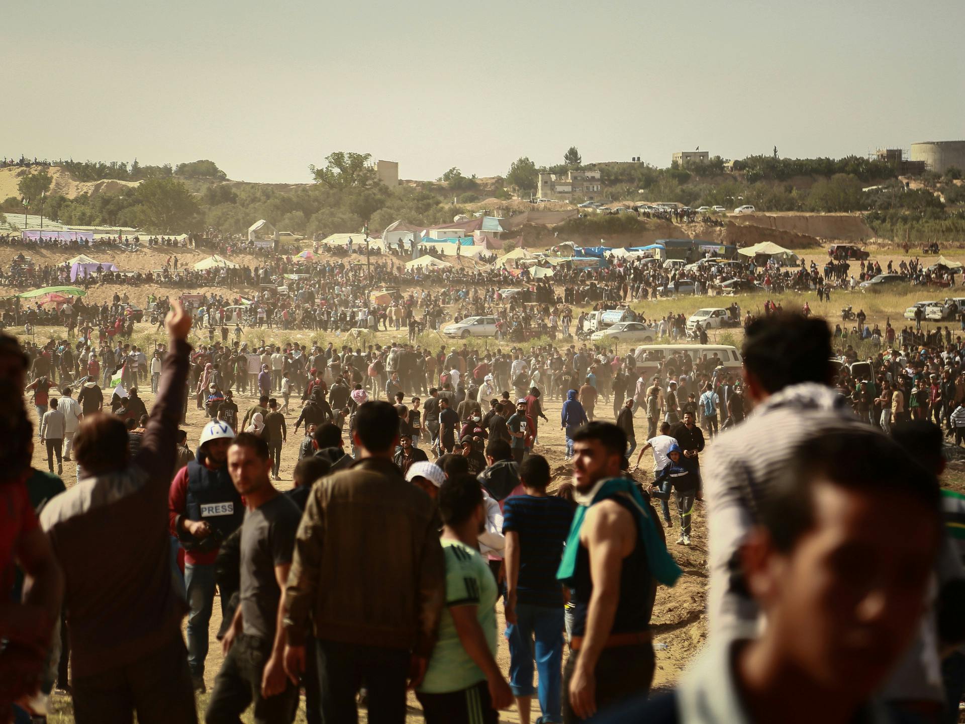 A large group of protesters march on a field in the Gaza Strip.