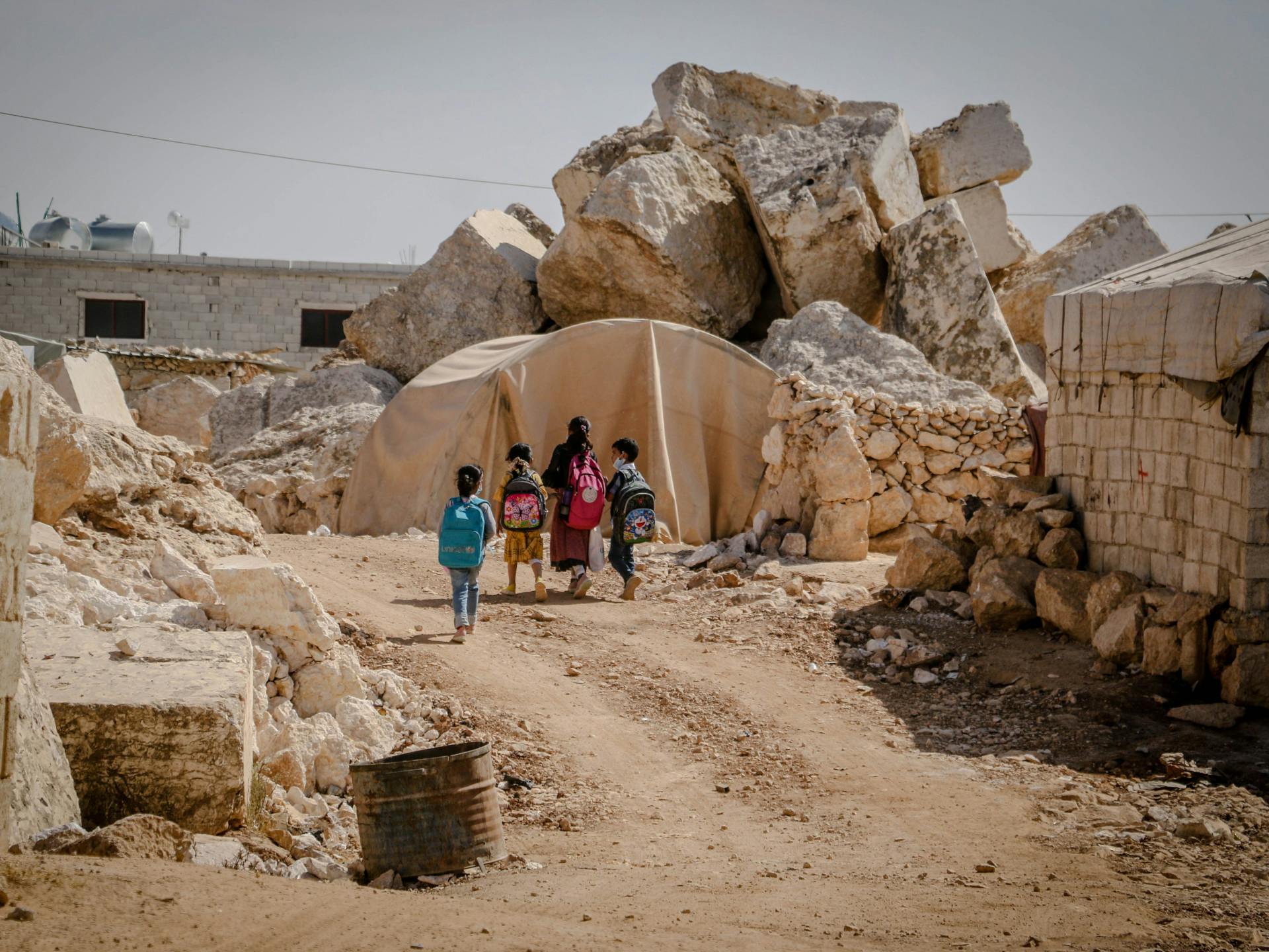 A group of children walk through the ruins of Idlib in Syria.