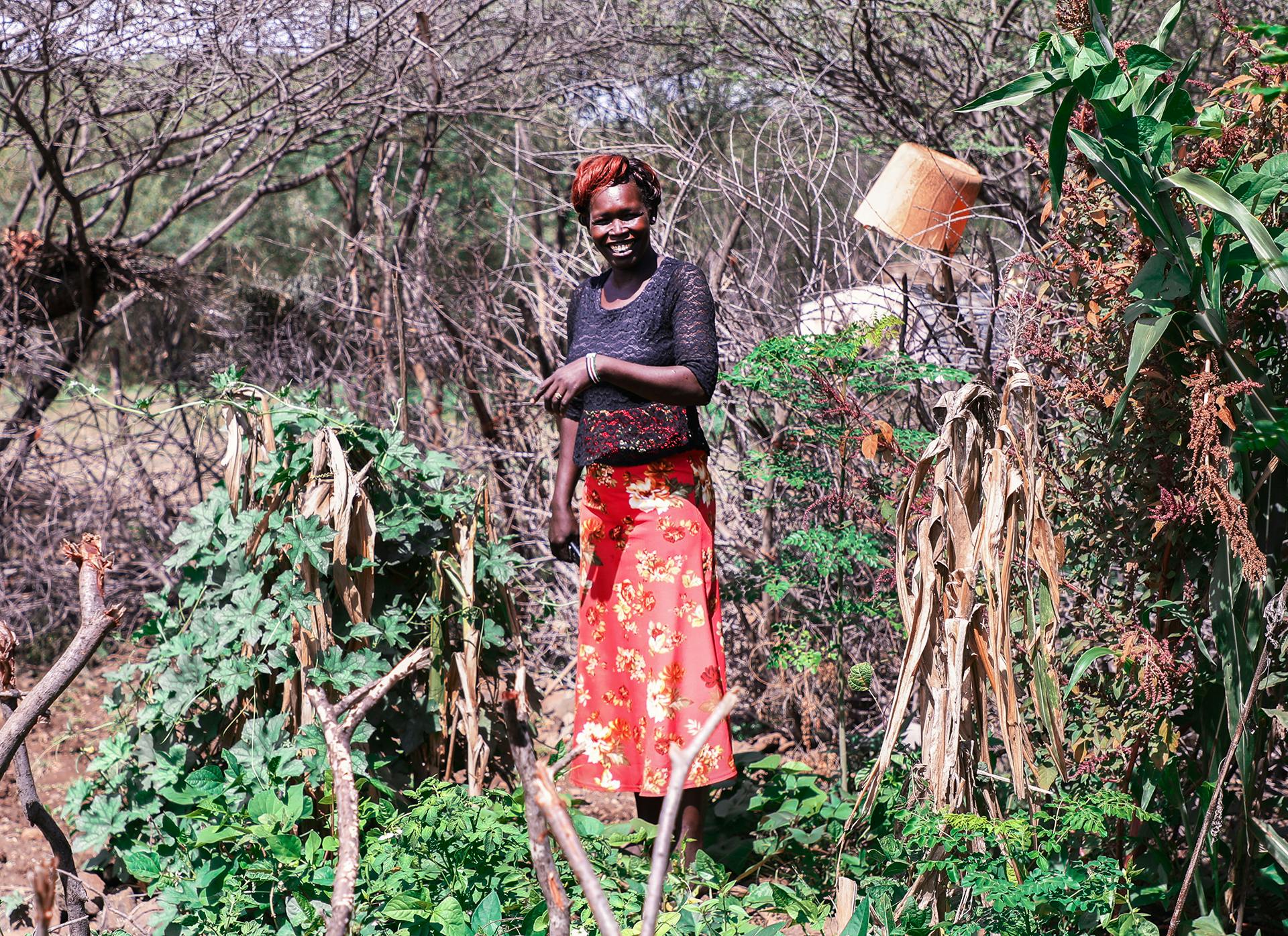 A Kenyan woman standing in a field.