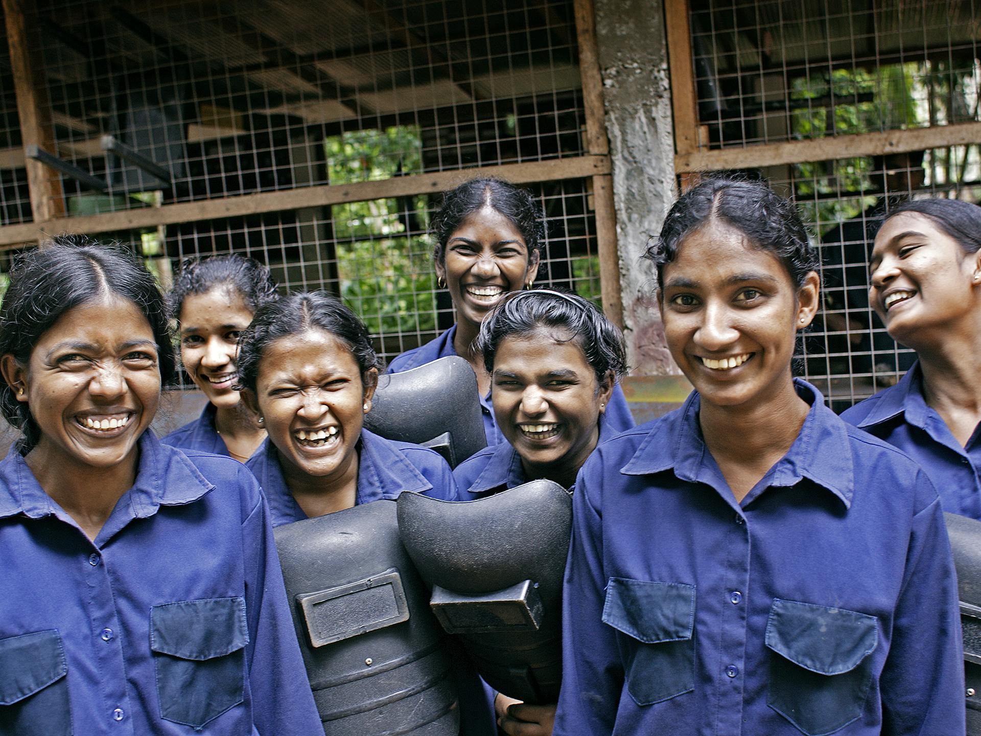 A group of women wearing blue working clothes.